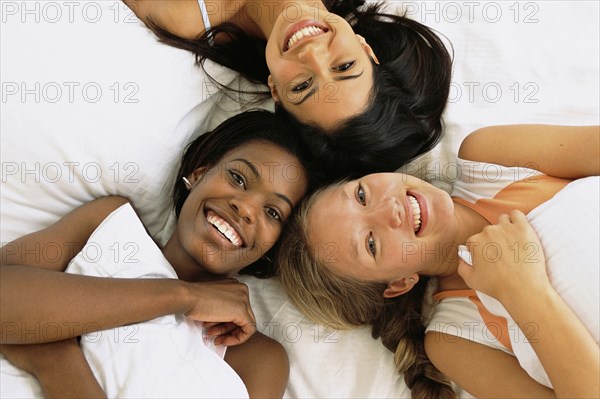 Friends relaxing together on bed