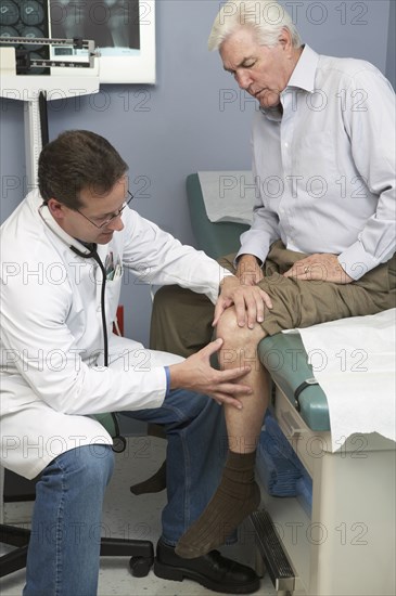 Doctor examining Senior man's knee