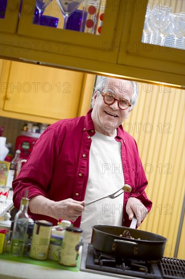 Senior man cooking in kitchen