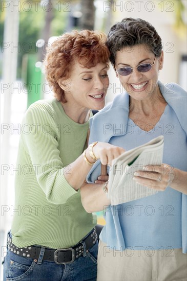 Senior women reading newspaper together