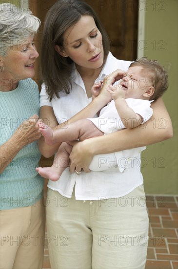 Mother and daughter comforting crying baby