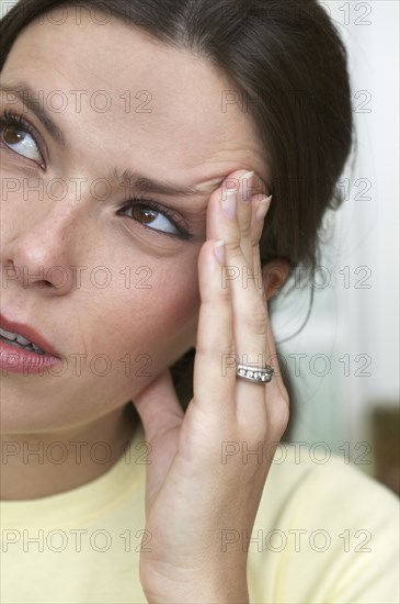 Hispanic woman rubbing her temple