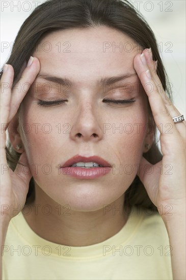 Hispanic woman rubbing her temples