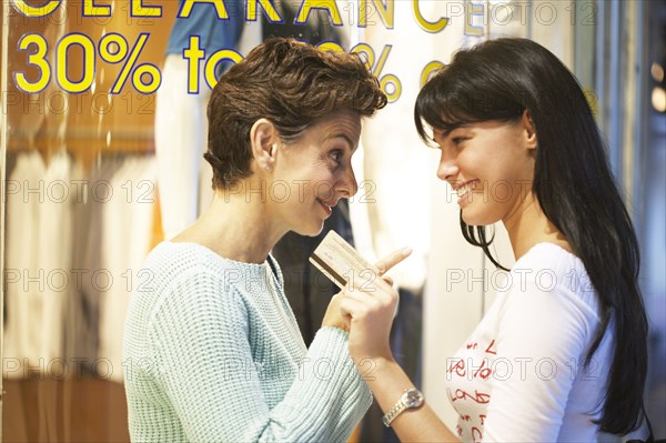 Women window shopping together on city street