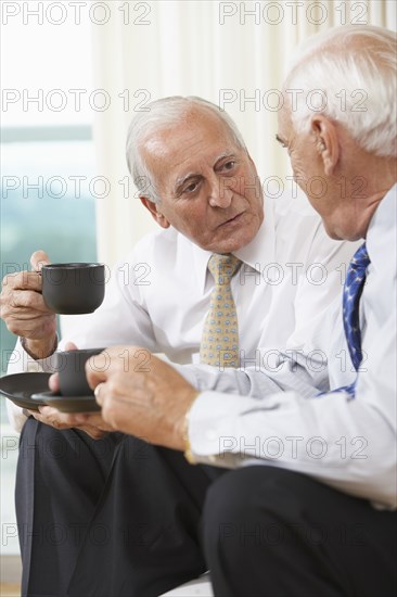 Senior businessmen having coffee on sofa