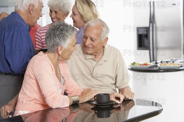 Senior couple having coffee in kitchen