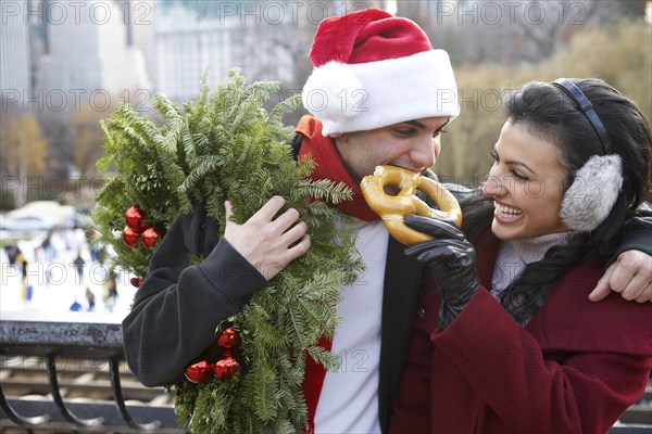 Couple eating pretzel on city street