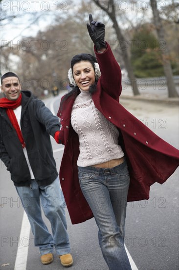 Couple hailing taxi in urban park