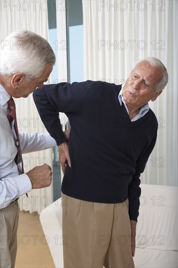 Senior man seeing doctor about back pain