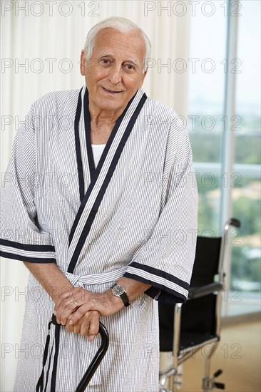 Senior man standing with cane