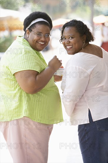 Women smiling together on city street