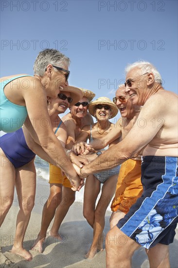 Senior friends cheering on beach