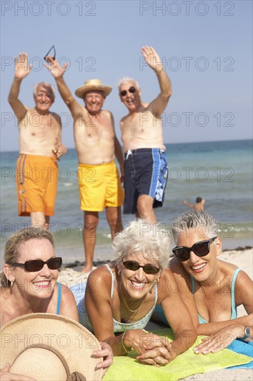 Senior friends relaxing on beach