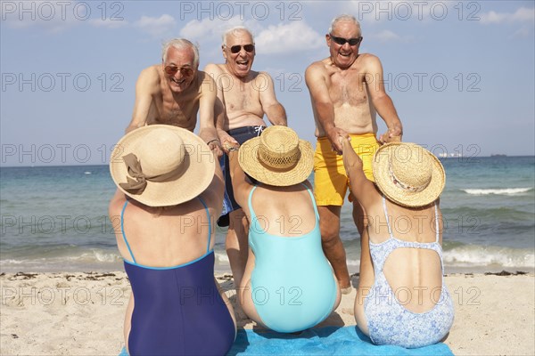 Senior couples playing on beach