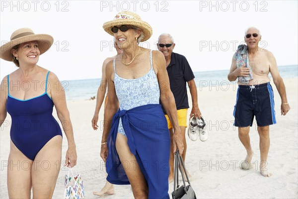 Senior friends walking on beach