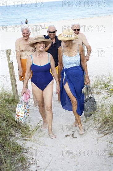 Senior friends walking on beach