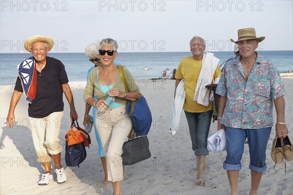 Senior friends walking on beach