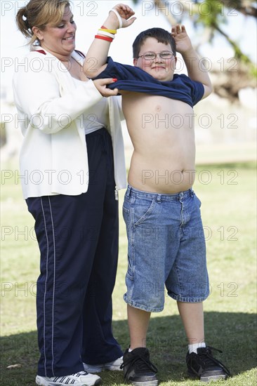 Mother helping son put on t-shirt