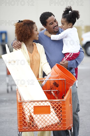 Family pushing shopping cart at home improvement store