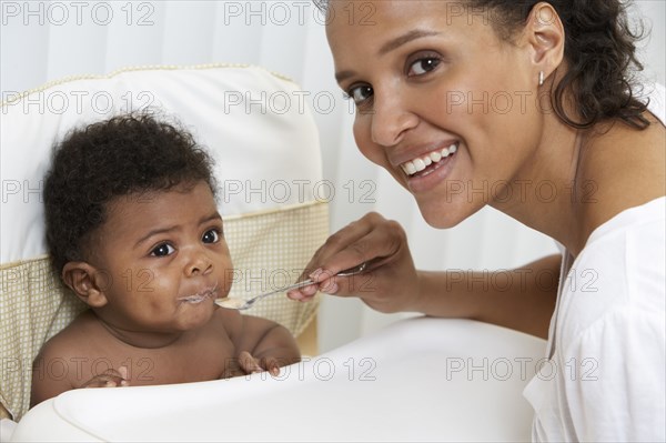 Mother feeding baby in high chair