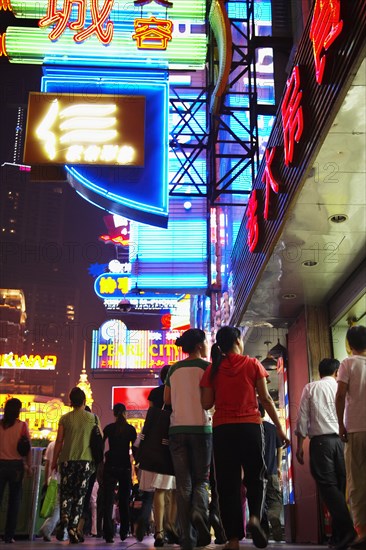 Couple on city street lit up at night