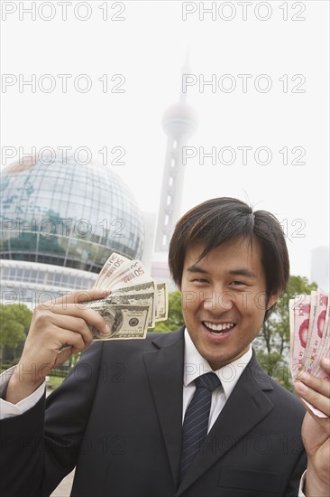 Chinese businessman holding wads of money