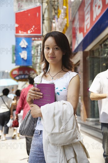 Chinese woman smiling on city street