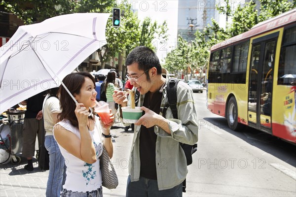 Chinese couple eating on city street