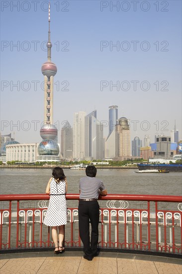 Chinese couple looking at city skyline