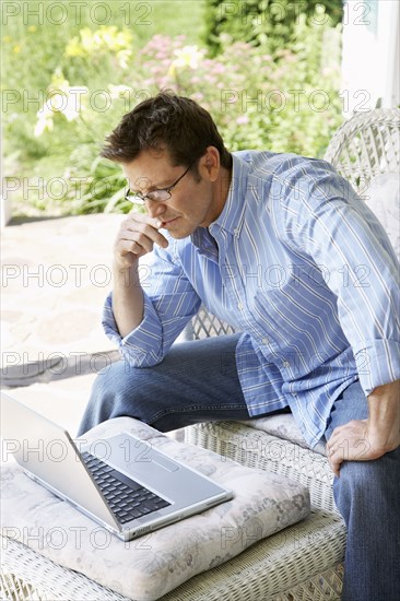 Man using laptop on patio