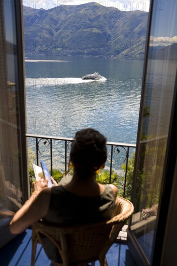 Woman overlooking rural lake from balcony