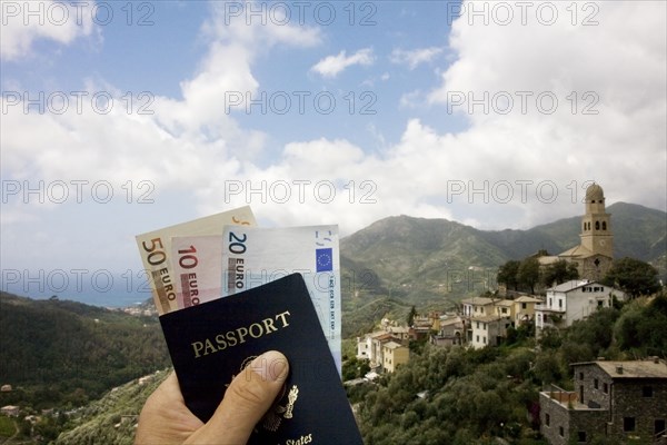 Passport and Euros overlooking rural landscape