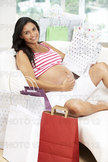 Pregnant Hispanic woman with shopping bags