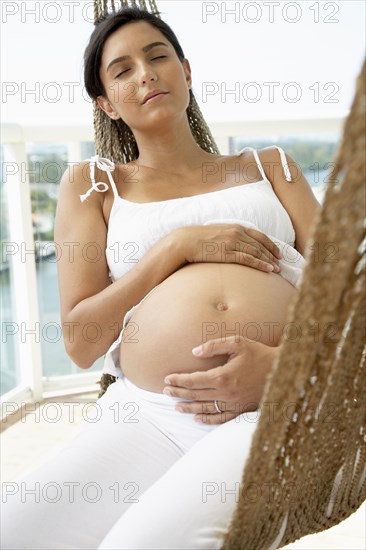 Pregnant Hispanic woman holding her belly