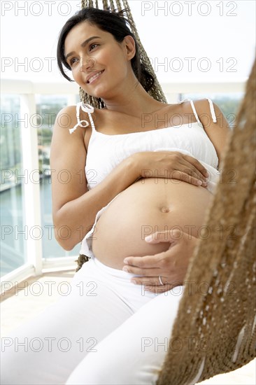 Pregnant Hispanic woman holding her belly