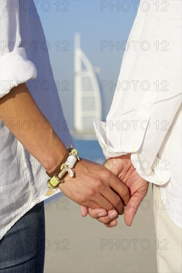 Couple holding hands on beach