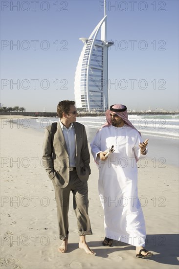 Businessmen walking on beach