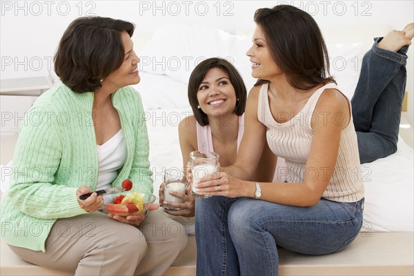 Hispanic mother and daughters relaxing together