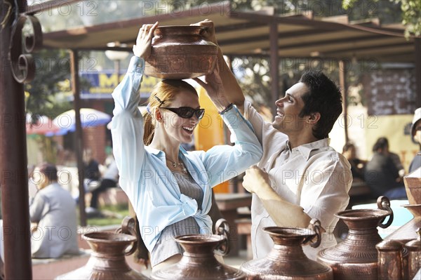 Couple admiring pottery at outdoor market