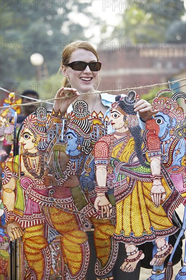 Caucasian woman admiring traditional art in outdoor market