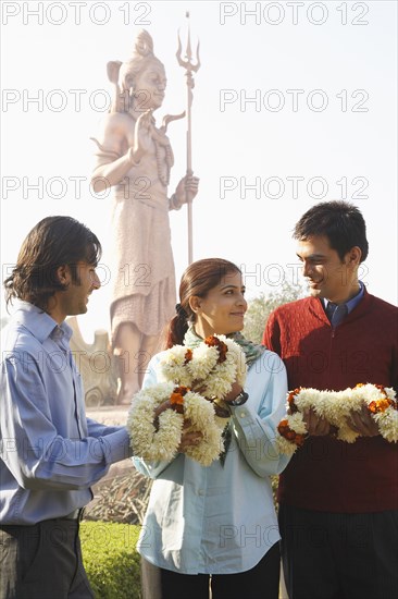 Indian family receiving flowers by monument