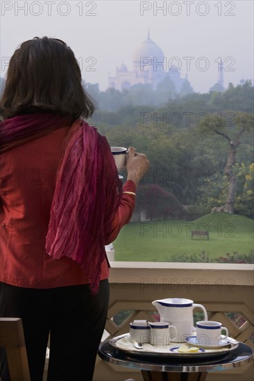 Caucasian woman overlooking Taj Mahal from balcony