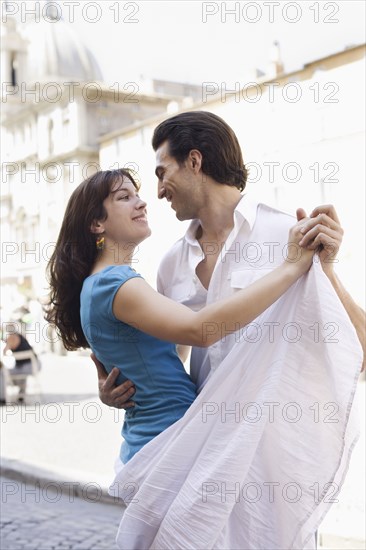 Caucasian couple dancing on city street