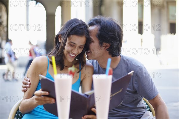 Couple reading menu at sidewalk cafe