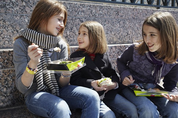 Girls eating together outdoors