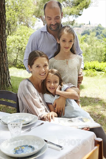 Family smiling together at table outdoors