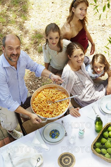 Family eating together at table outdoors