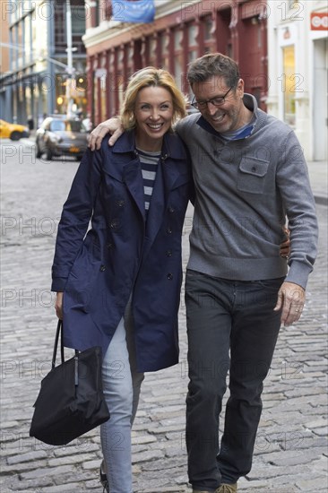 Caucasian couple walking on city street