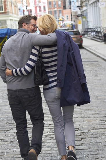 Caucasian couple walking on city street