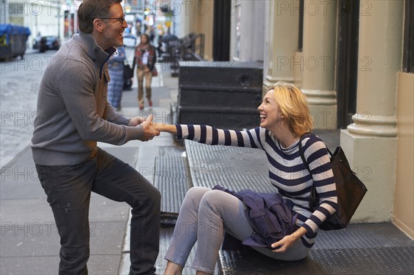 Caucasian couple playing on city sidewalk